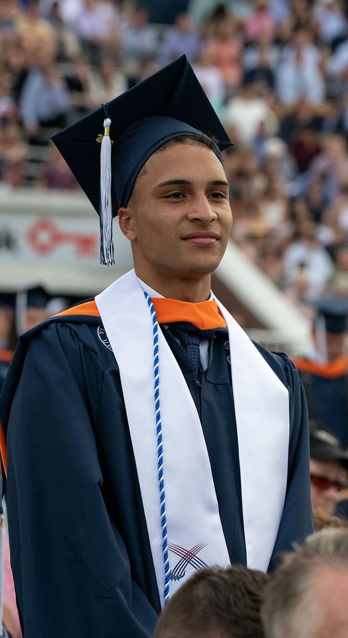 A student stands during ר's commencement ceremony.